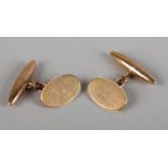 A PAIR OF GEORGE V CUFFLINKS BY G.H. JOHNSTONE & CO. in 9ct rose gold, the oval engine turned
