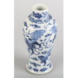 A CHINESE BLUE AND WHITE VASE OF BALUSTER FORM, painted with Buddhist lions amongst clouds, Kangxi