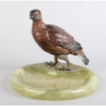 A COLD PAINTED BRONZE FIGURE OF A GROUSE mounted on an onyx dished base, 18cm high x 20cm