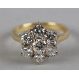 A DIAMOND CLUSTER RING in 18ct yellow and white gold, the brilliant cut stones claw set within a