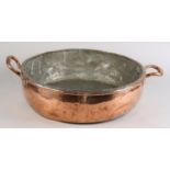 A LARGE TWO HANDLED COPPER PAN, early 20th century of shallow circular form, by Shirras Laing & Co