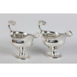 A PAIR OF GEORGE III SILVER SAUCEBOATS, London 1769, having gadroon rim and oval pedestal foot, leaf