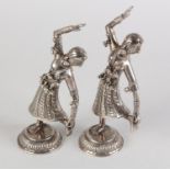 A PAIR OF INDIAN SILVER DANCING FIGURES, wearing elaborate costume hung with bells, on a raised