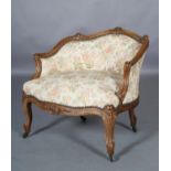 A 19TH CENTURY FRENCH WALNUT FAUTEUIL with rubbed gilding having a leaf carved and moulded