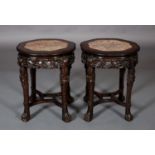 A PAIR OF CHINESE HARDWOOD AND ROUGE MARBLE INSET URN STANDS, shaped circular outline with beaded