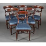 A REGENCY SET OF SIX MAHOGANY DINING CHAIRS, the shaped bar rail, carved with fluting and flower