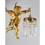 A GILT METAL CHERUB WALL SCONCE, pendant from a ribbon tied writhen arm and hung with a circlet of