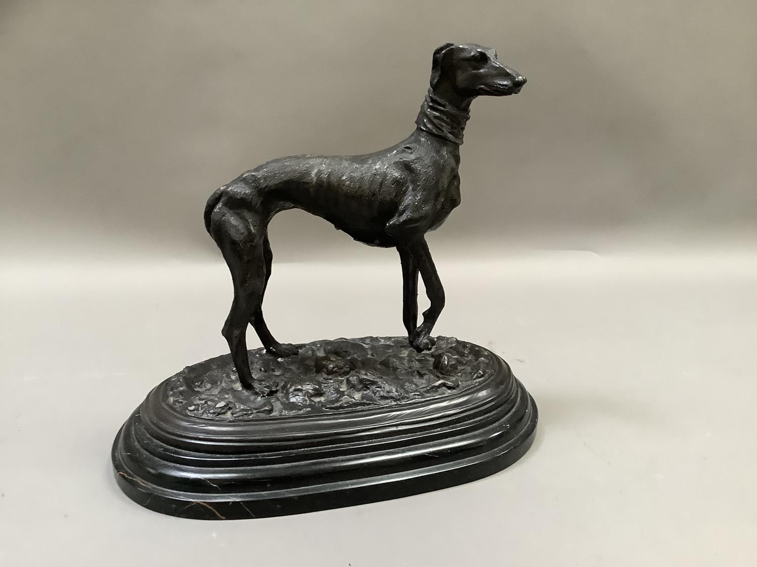 A reproduction bronzed figure of a greyhound standing on naturalistic ground, after Mene, raised