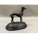 A reproduction bronzed figure of a greyhound standing on naturalistic ground, after Mene, raised