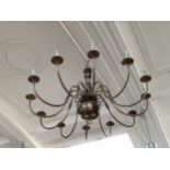 A reproduction Dutch antique style centre light fitting of twelve lights having scrolled arms and