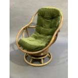 A late 60s/early 70s bamboo framed swivel armchair (NB the seat cushion does not meet current fire