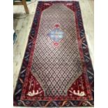 A Middle Eastern style runner the camel field having a central medallion of pale blue with