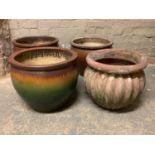 Four various garden planters glazed in shades of brown and a terracotta of ribbed form, various