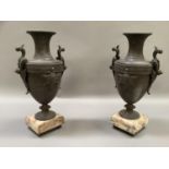 A pair of late 19th/early 20th century French bronzed metal two handled urns on knopped sockle,