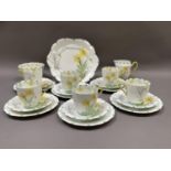 A Fenton china tea service printed and painted with daffodils on a white ground with green feathered