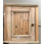 A small pine hanging corner cupboard with single door