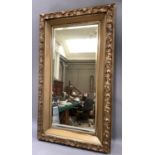 A large gilt framed wall mirror, c-scrolls and leafage, 130cm by 74cm