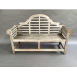 A Lutyens style teak bench with arched back together with a green seat cushion