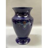 A Denby hand thrown vase no.112-D, the dark blue ground glazed and tube lined with flower motif in
