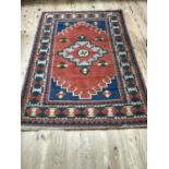 Mid 20th century Caucasian rug having a fox red ground with central medallion, blue spandrel corners