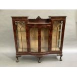 A 1920s mahogany semi bow front display cabinet having an arched back above a recessed centre and