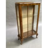 A 1940s walnut and glazed door display cabinet on short cabriole legs, 60cm wide