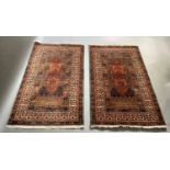 A pair of modern Persian style rugs in fox red, blue and ivory, measuring 89cm x 165cm