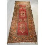 A late 19th/early 20th century Middle Eastern rug having a red field with two medallions within