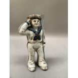 A cast iron money box in the form of a sailor holding an oar