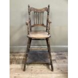 An early 20th century child's high chair with rail back and turned framing, converting to a play