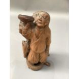 A 19th century Chinese carved fruitwood figure of a man and monkey grappling with a large snake,
