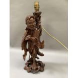 A Chinese root carving of a male figure carrying a staff and a bird in his hand, as a lamp, 42cm