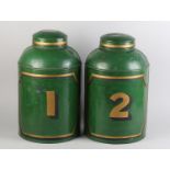 A pair of 19th century toleware tea canisters, cylindrical, the green ground with panel and