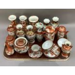 A quantity of Japanese pottery of typical decoration in iron red and gilt with panels of figures and