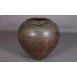 A large glazed earthenware vessel, of tapered compressed globular form with three lugs to the