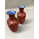 A pair of Cinnabar vases carved with panels of sinuous dragons amongst a scrolled ground, 23cm high