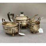 A George V three piece silver tea service, oblong with gadroon rims and panelled body on ball