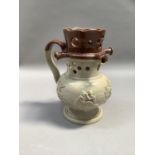 A salt glaze puzzle jug, brown dipped rim and sprigged with toping figure, tree and windmill, 19cm