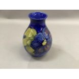 A Moorcroft vase painted and tube lined with clematis pattern in shades of mauve, blue and green