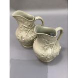 Two 19th century salt glaze jugs moulded in relief with trailing vine, graduated size, 19cm and 17cm