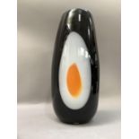 A Studio glass vase of ovoid form, the black glass centred with a yellow and white egg type oval