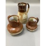 A pair of Denby graduated stoneware brown dipped jugs moulded in relief with vine, trees, figures,