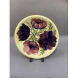 A Moorcroft pottery plaque, tube lined and painted with the anemone pattern in shades of mauve and