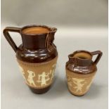 A pair of graduated Royal Doulton stoneware jugs, the buff and brown dipped body decorated with