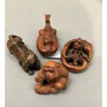 Four carved wood netsukes including monkey and young, dog, a figure relaxing in a boat and a
