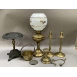A Victorian cast iron and brass trivet, a pair of brass candlesticks with drip trays and dished