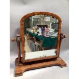A Victorian walnut dressing table mirror, arched outline on ring turned uprights with lobed finials,