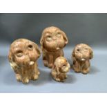 A set of four Crown Devon dogs of graduated size in mottled ochre glaze, originally with glass