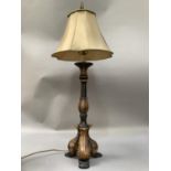 A black and gilt leaf capped column table lamp on three scroll feet, with shade, 89cm high