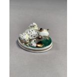 A Royal Worcester figure of a frog with dark bulging eyes and gilt spotted body on a green oval base